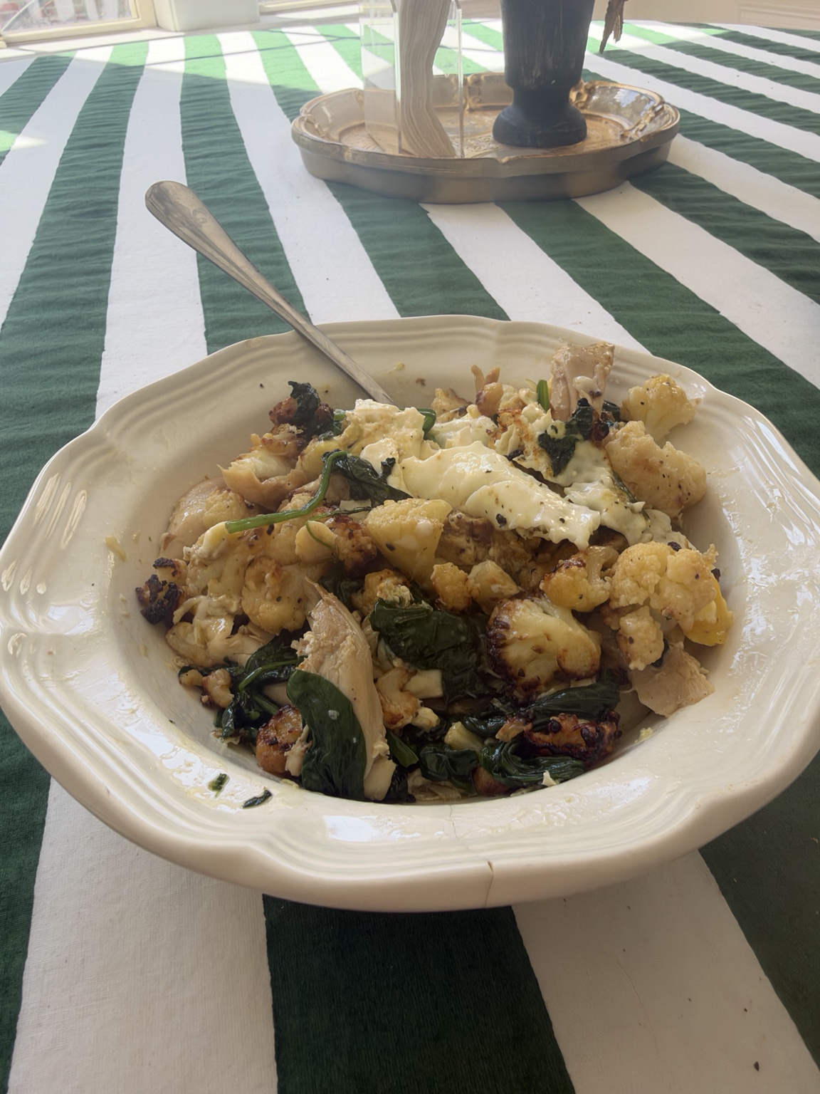 The plated leftover skillet with chicken, cauliflower, spinach, eggs and cottage cheese