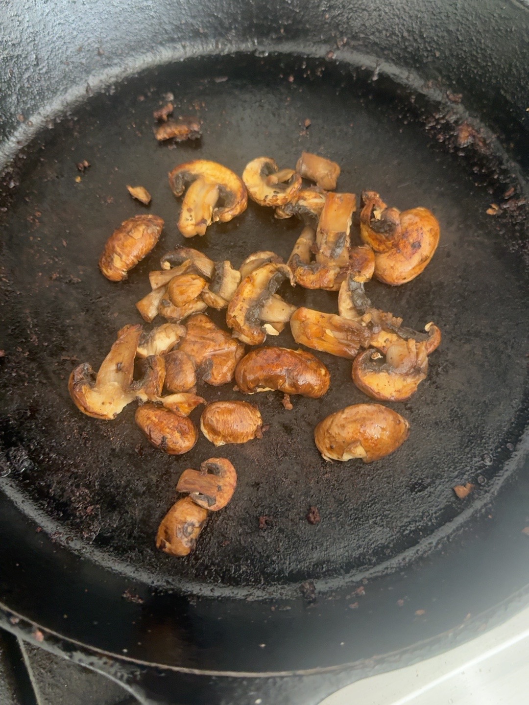 Browned sliced mushrooms in the cast-iron skillet